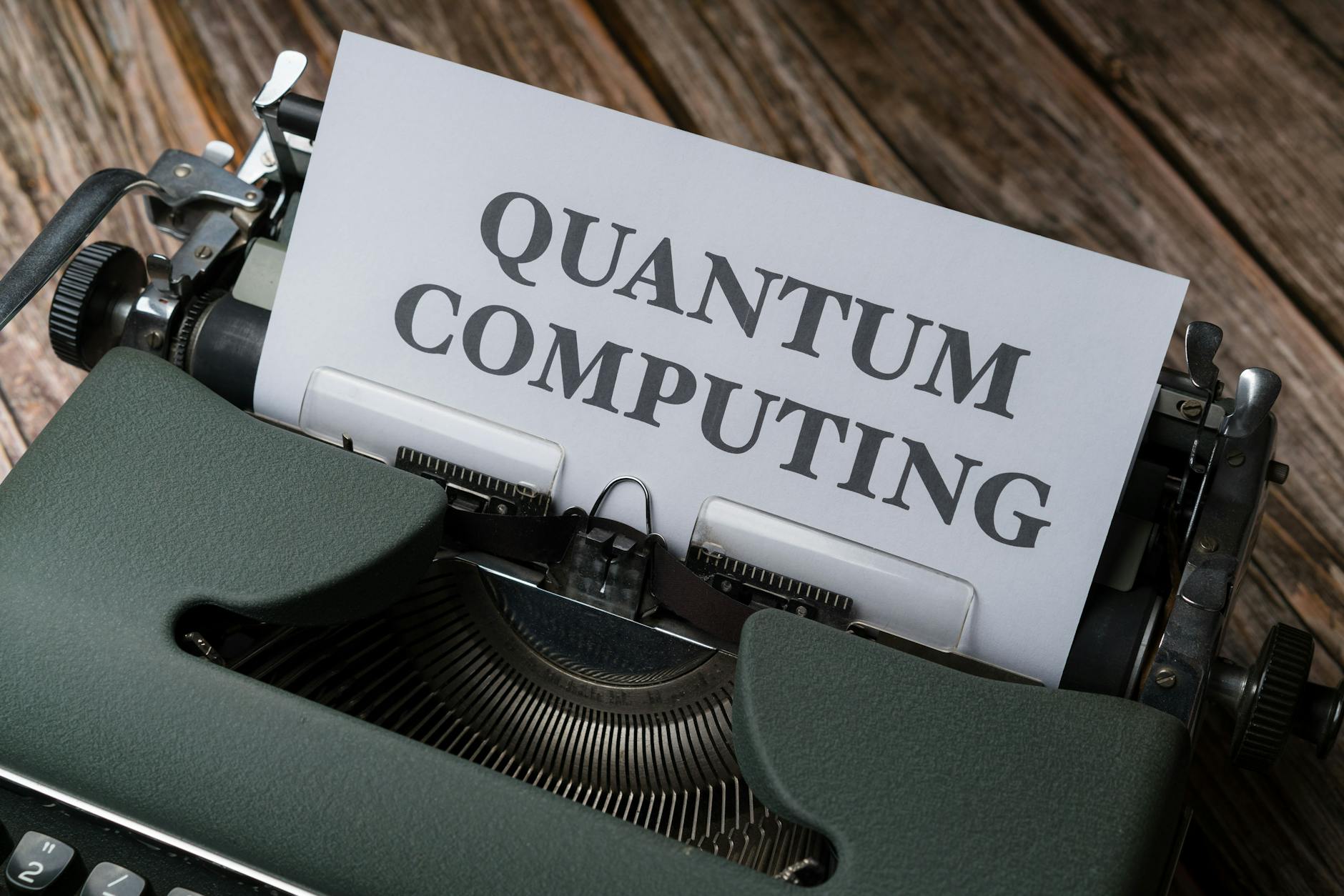 Stara maszyna do pisania z napisem quantum computing na drewnianym stole