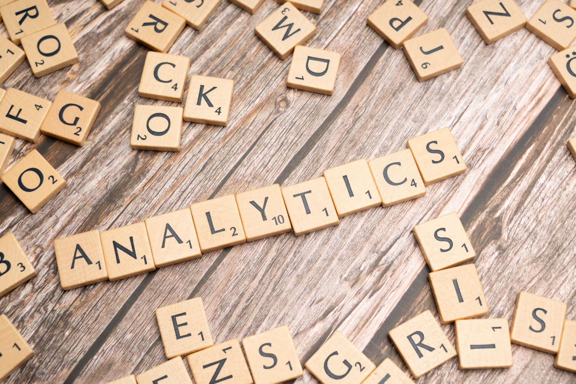 Klocki Scrabble układające się w słowo Analytics na drewnianym blacie