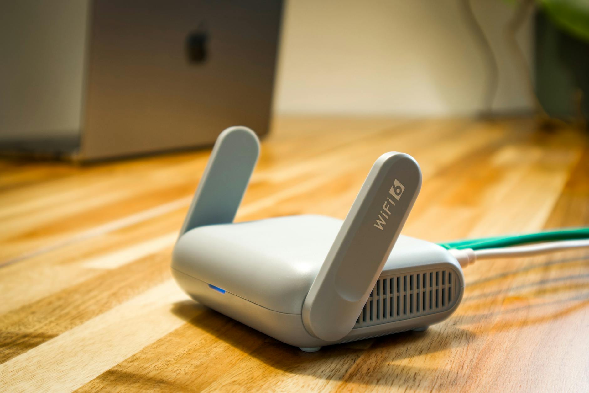 Router WiFi 6 z antenami na drewnianym biurku w nowoczesnym mieszkaniu