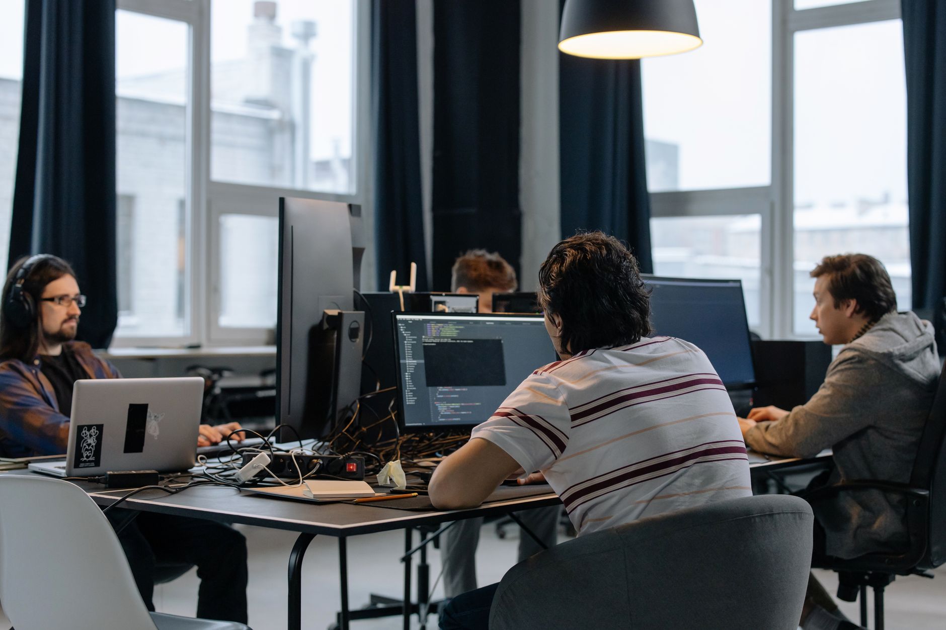 Zespół programistów współpracuje przy komputerach w nowoczesnym biurze