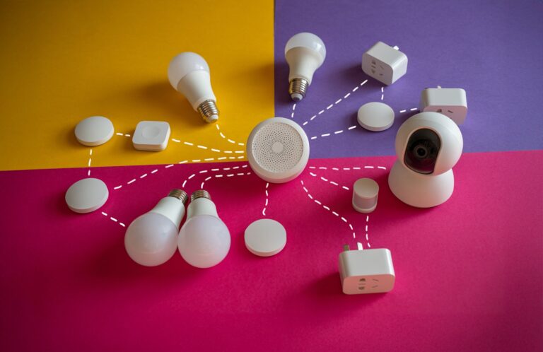 Inteligentne żarówki i gniazdka smart home na kolorowym tle